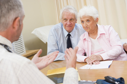 Senior man and woman talking to their doctor