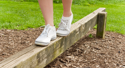 girl walking on wooden balance beam