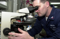 man looking into microscope