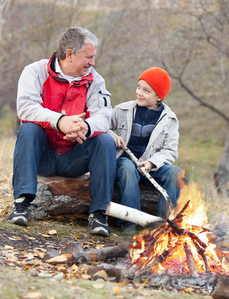 man and boy by campfire