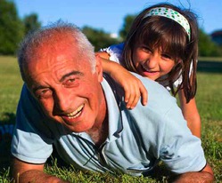 grandpa with granddaughter sitting on grass