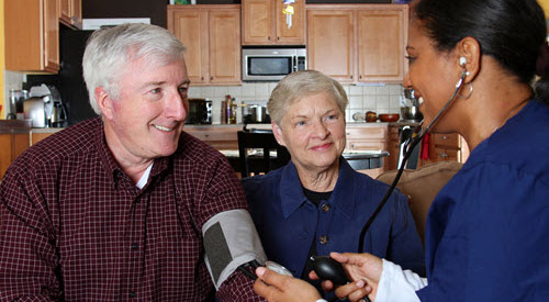 Middle aged man having blood pressure taken by a nurse