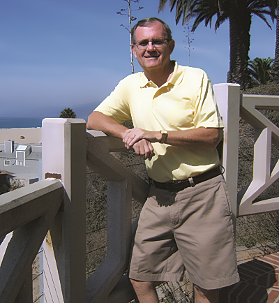 Dave Anderson standing by fence on beach