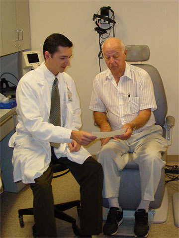 Photo of a doctor reviewing an educational information sheet with a patient.