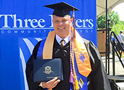 A man wearing a graduation cap and gown