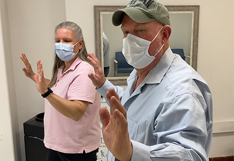 Recreation Therapist leads a Veteran through Tai Chi exercise. 