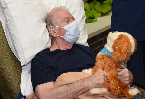 Veteran holding robotic dog.