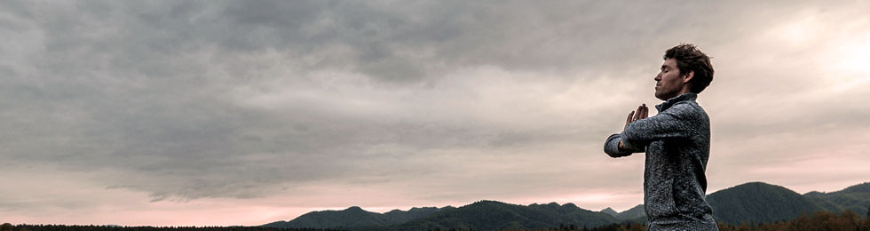 man meditating at sunset