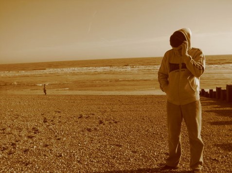 A Veteran standing on a beach.