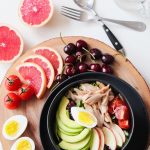 Bowl of cherries, chicken, eggs, avocado, tomatoes, and grapefruits.