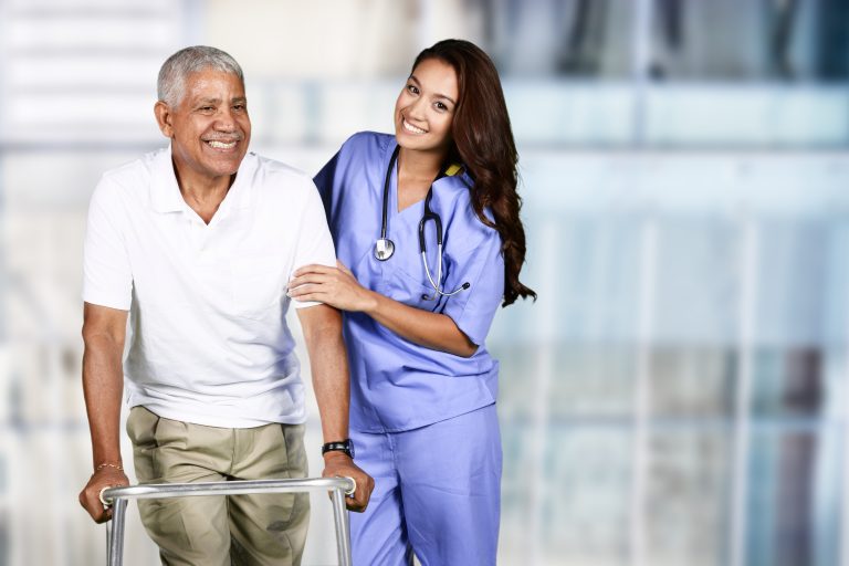 A young female clinician walking with an older Veteran using a walker.