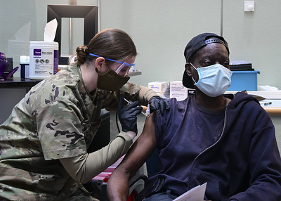 Nurse injecting COVID-19 vaccine to patient